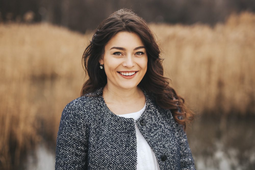 Young woman wearing autumn clothes smiling.